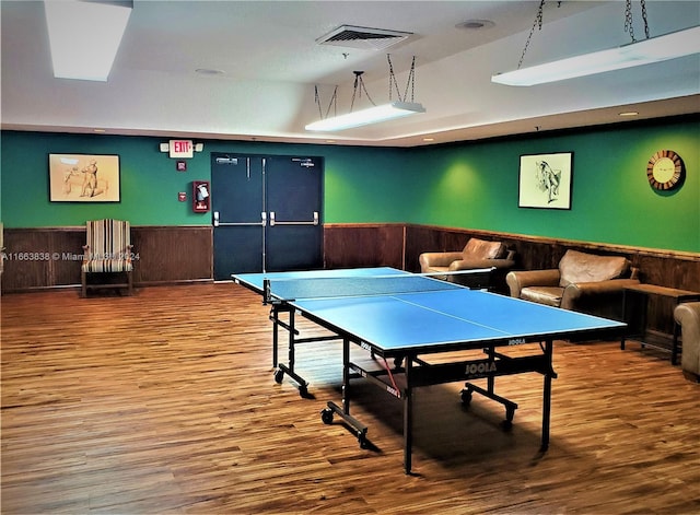 recreation room featuring wood walls and hardwood / wood-style floors