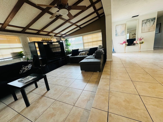 living room with lofted ceiling, a textured ceiling, ceiling fan, and light tile patterned floors