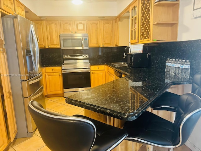 kitchen featuring kitchen peninsula, tasteful backsplash, stainless steel appliances, and light tile patterned floors