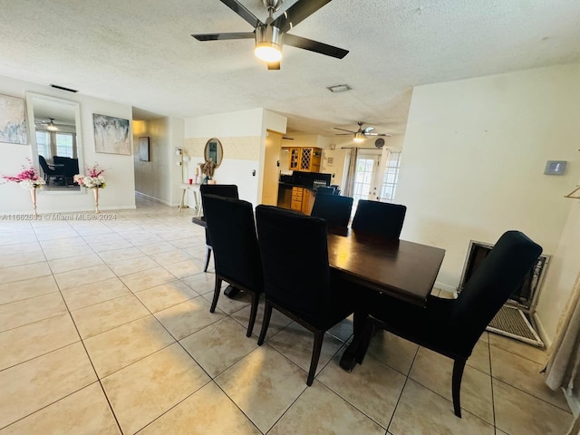 dining space with a textured ceiling and light tile patterned floors