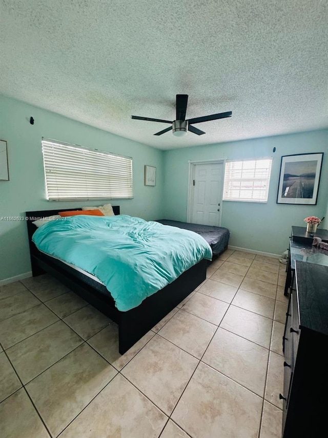 tiled bedroom with a textured ceiling and ceiling fan