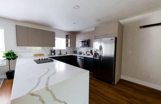 kitchen featuring gray cabinetry, dark hardwood / wood-style flooring, stainless steel appliances, and light stone countertops