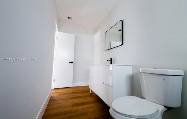 bathroom featuring vanity, hardwood / wood-style floors, and toilet