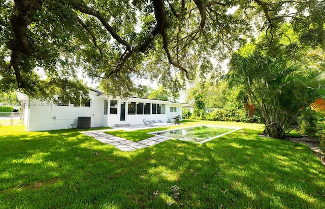 view of yard with central air condition unit and a patio area