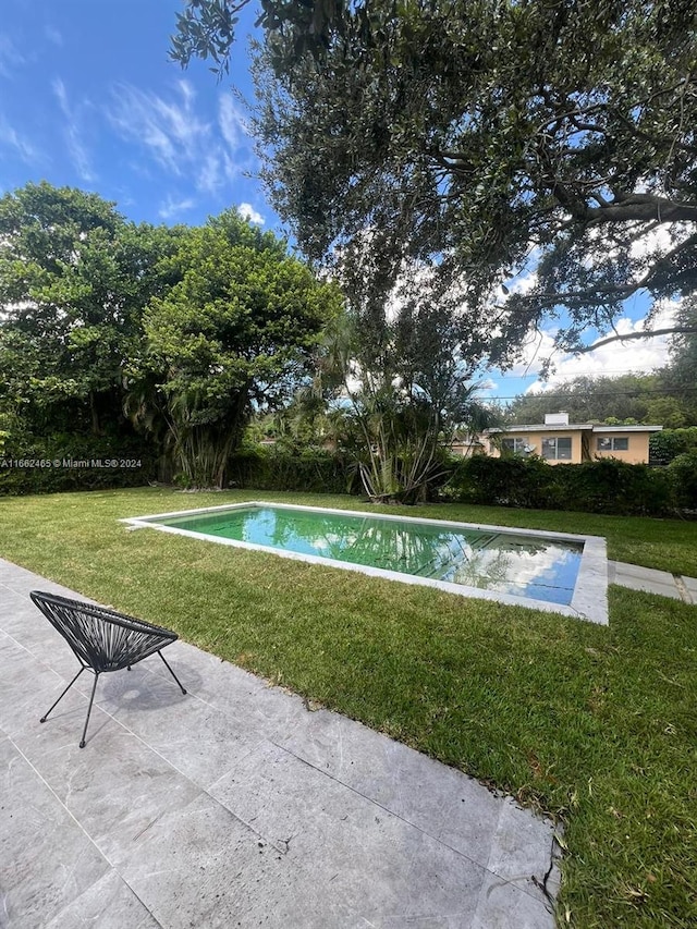 view of swimming pool featuring a lawn and a patio