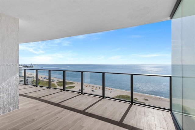 balcony with a water view and a view of the beach