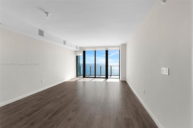 unfurnished room with dark hardwood / wood-style floors and expansive windows