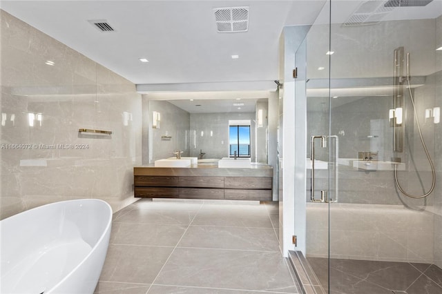 bathroom with tile walls, shower with separate bathtub, tile patterned floors, and vanity