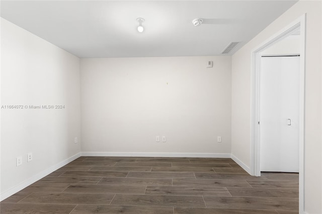 empty room with dark hardwood / wood-style flooring