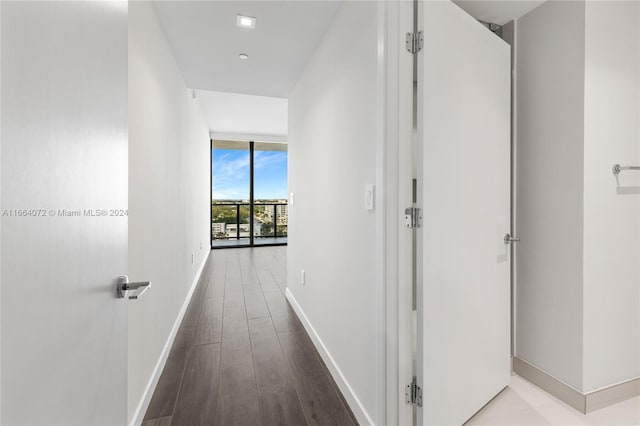 hall with wood-type flooring and floor to ceiling windows