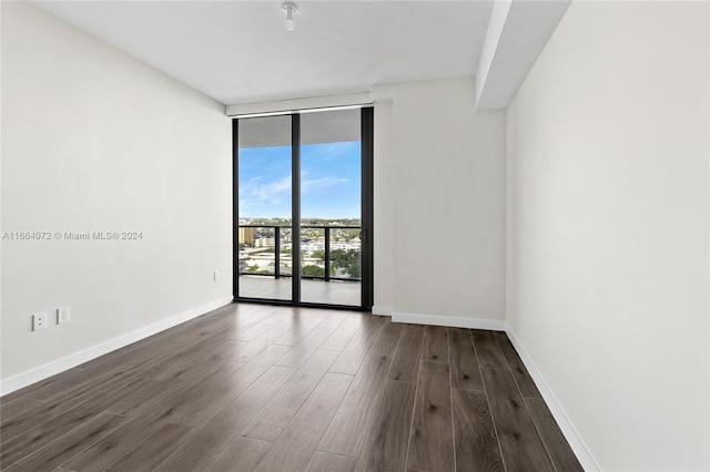 unfurnished room featuring dark wood-type flooring and expansive windows