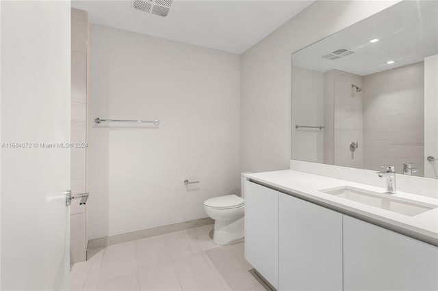 bathroom featuring tiled shower, vanity, and toilet