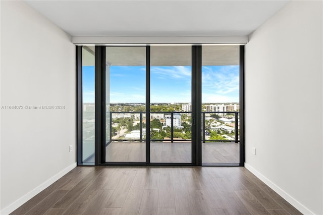 empty room featuring a wall of windows and dark wood-type flooring