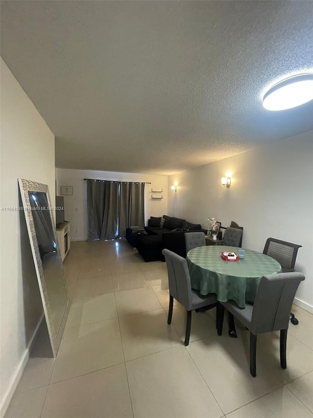 tiled dining area featuring a textured ceiling