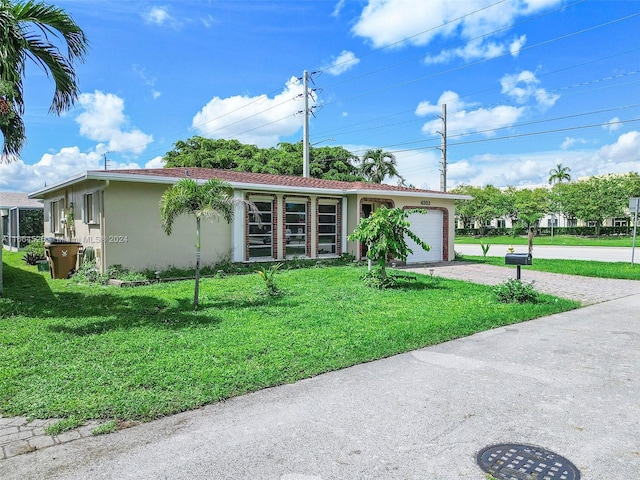 single story home with a garage and a front lawn