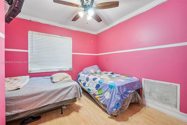 bedroom with ceiling fan, hardwood / wood-style flooring, and crown molding