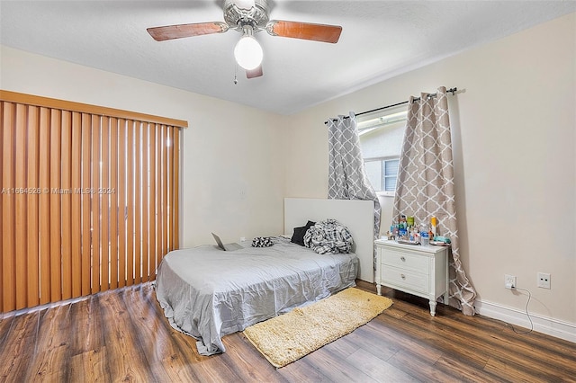 bedroom with a textured ceiling, ceiling fan, and dark hardwood / wood-style flooring