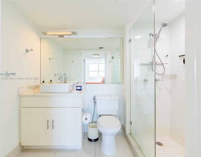 bathroom with tile patterned floors, walk in shower, vanity, and toilet