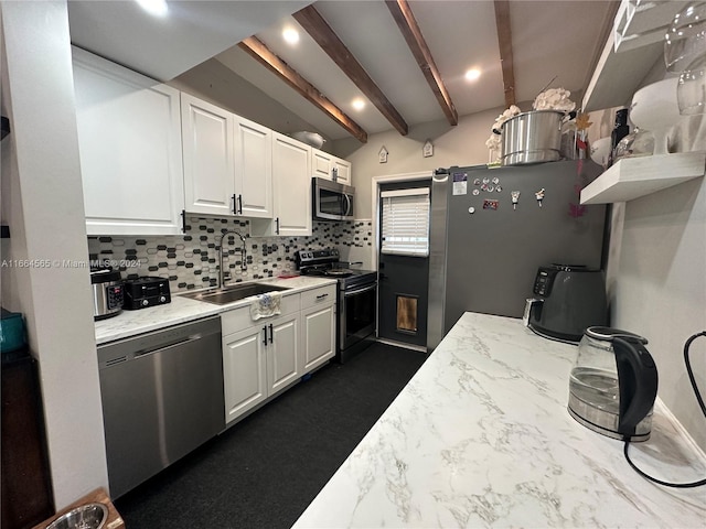 kitchen featuring appliances with stainless steel finishes, beam ceiling, sink, and white cabinetry