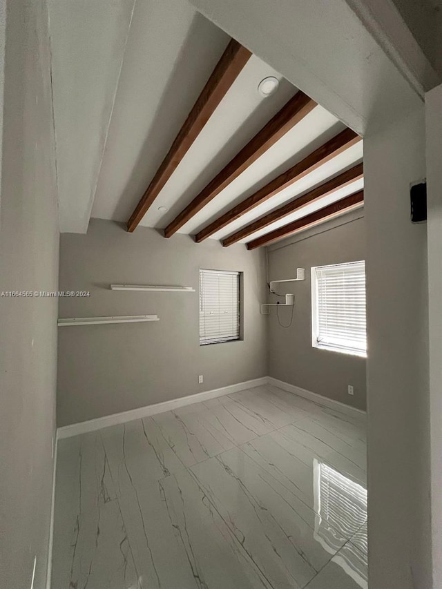 empty room featuring beamed ceiling