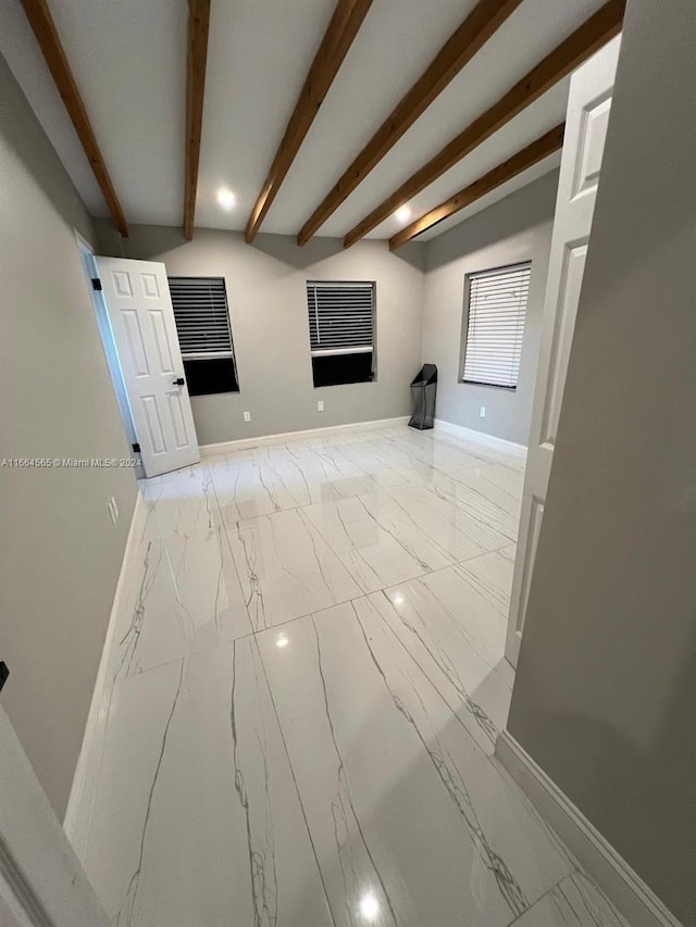 unfurnished living room featuring beamed ceiling