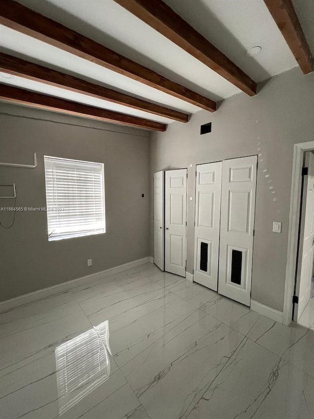 unfurnished bedroom with beamed ceiling