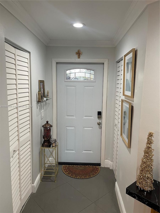 doorway with crown molding and dark tile patterned flooring