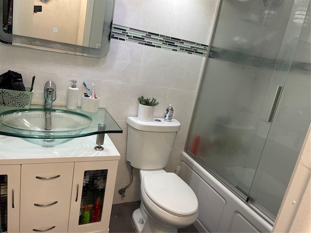 full bathroom featuring decorative backsplash, tile walls, vanity, enclosed tub / shower combo, and toilet