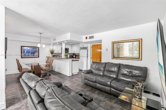 living room with a textured ceiling and dark tile patterned floors