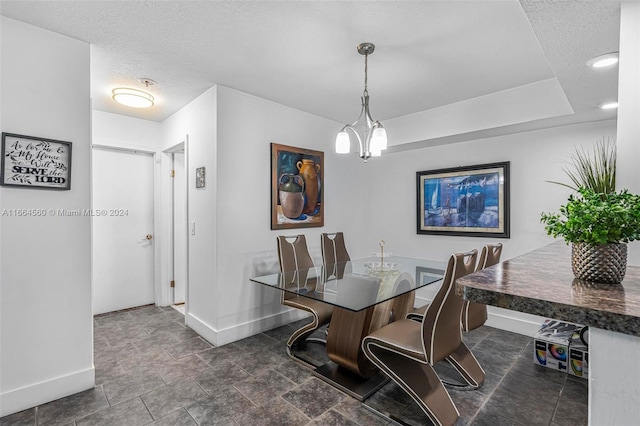 dining area featuring an inviting chandelier and a textured ceiling