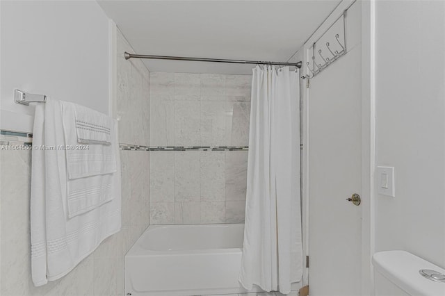 bathroom with toilet and shower / bath combo with shower curtain