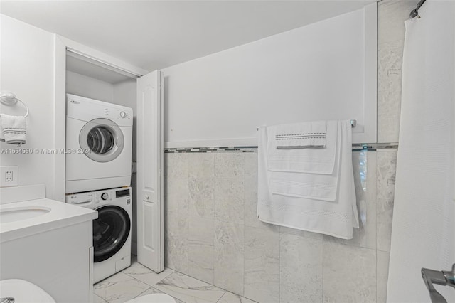 interior space with stacked washer / dryer, tile walls, and curtained shower