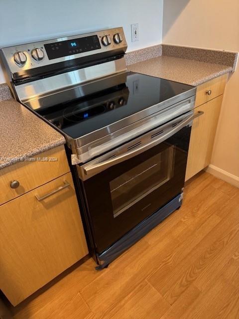 kitchen with light hardwood / wood-style flooring and range with electric cooktop