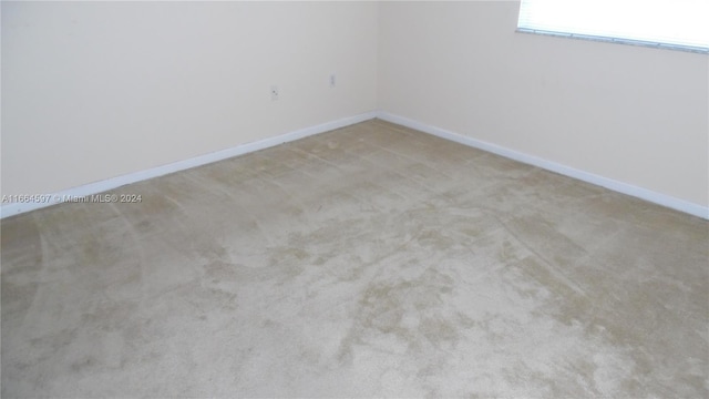 unfurnished room featuring light carpet