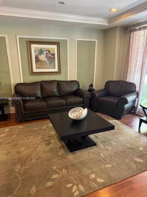 living room featuring wood-type flooring and crown molding