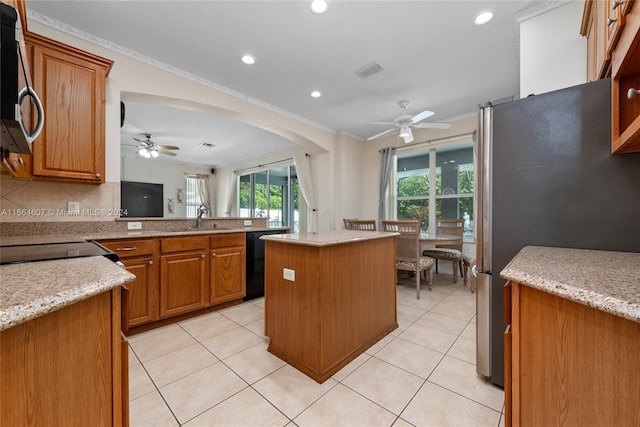 kitchen with a center island, decorative backsplash, black appliances, ornamental molding, and ceiling fan