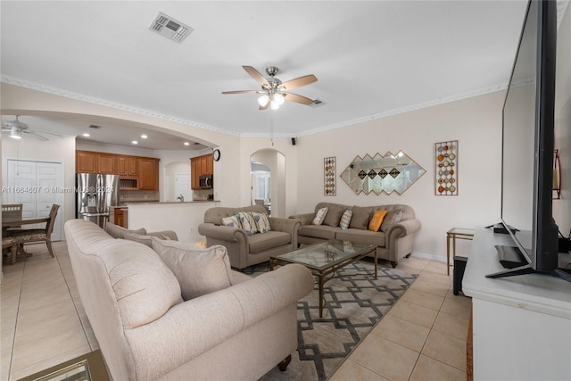 tiled living room with ceiling fan and ornamental molding