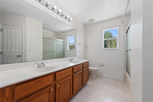 full bathroom featuring vanity, plenty of natural light, toilet, and tile patterned floors