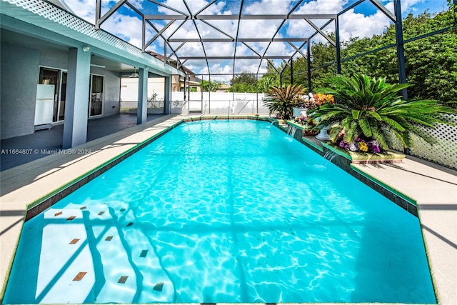 view of pool with a patio area, a lanai, and pool water feature