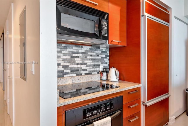 kitchen featuring light stone counters, decorative backsplash, and black appliances