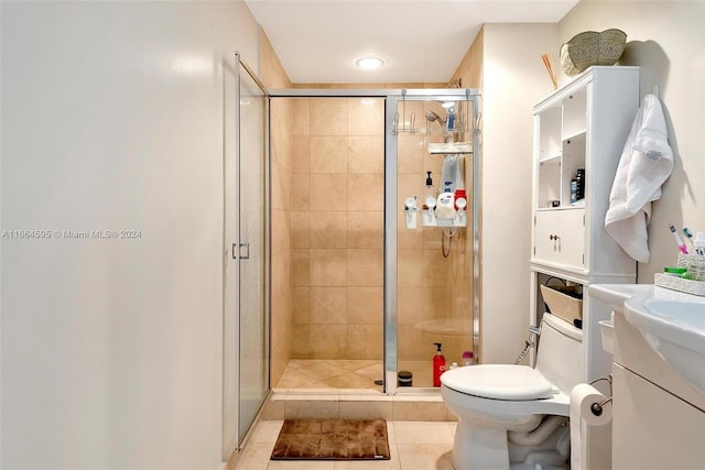 bathroom featuring tile patterned flooring, vanity, toilet, and an enclosed shower