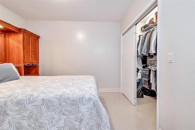 bedroom with light tile patterned floors and a closet