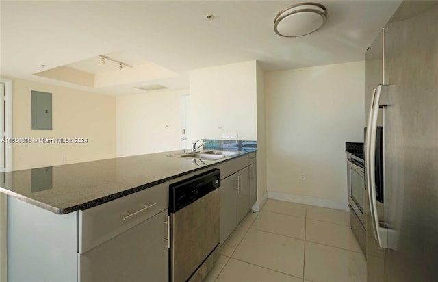 kitchen featuring electric panel, sink, appliances with stainless steel finishes, light tile patterned floors, and dark stone countertops