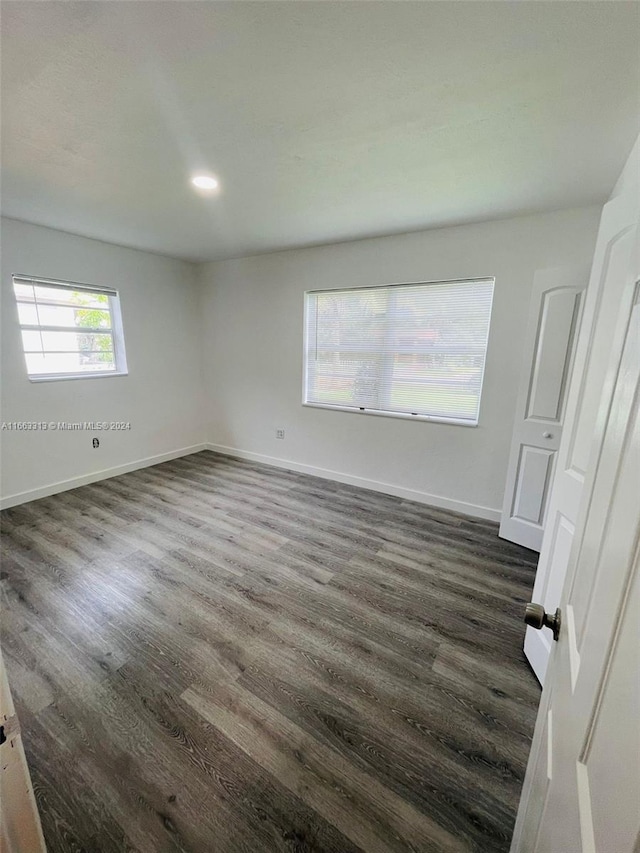 empty room with dark hardwood / wood-style flooring