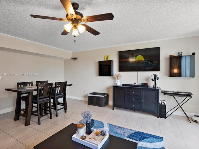 living room featuring ceiling fan, crown molding, light tile patterned floors, and a textured ceiling