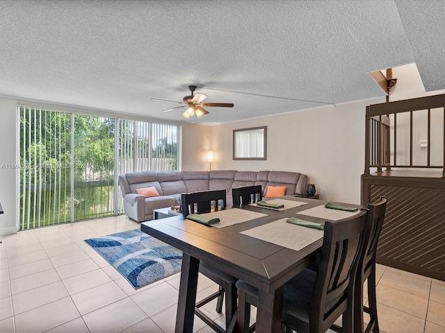 tiled dining area with ceiling fan and a textured ceiling