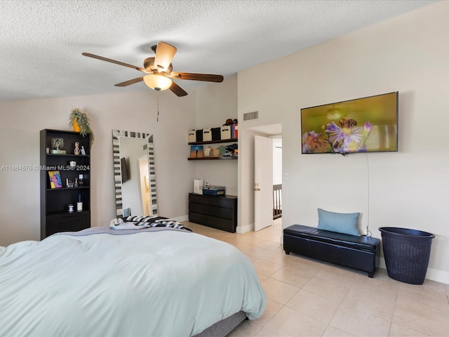 tiled bedroom with a textured ceiling and ceiling fan