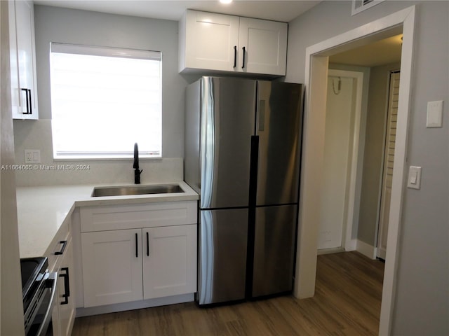 kitchen with white cabinets, stainless steel appliances, sink, and dark hardwood / wood-style flooring