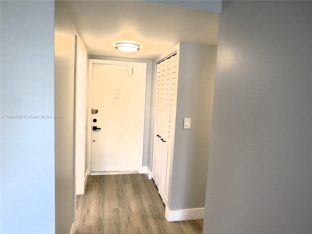 corridor with hardwood / wood-style flooring