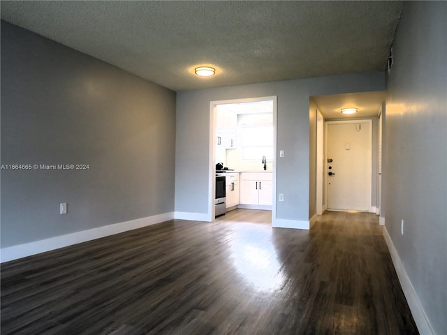 spare room featuring a textured ceiling, dark hardwood / wood-style floors, and sink